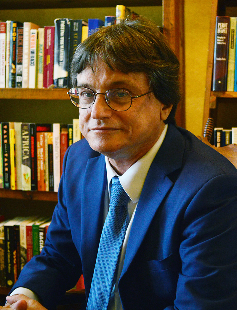 Dr. Michael Phillips, headshot in front of a bookshelf full of books