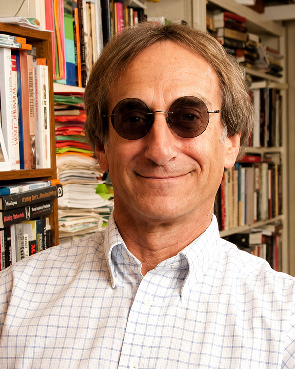 Dr. Rick Halperin, Smiling in front of bookshelf